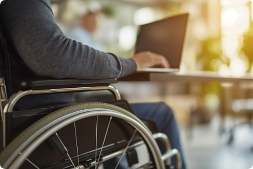 車椅子の利用者がノートパソコンを操作している様子の写真